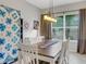 Bright dining room with wooden table, white chairs, and a large quilt on the wall at 296 Del Sol Ave, Davenport, FL 33837