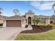 One-story house with brown garage door and landscaped front yard at 296 Del Sol Ave, Davenport, FL 33837