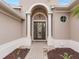 Front entry with arched doorway, columns, and decorative glass door at 296 Del Sol Ave, Davenport, FL 33837