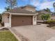 Two-car garage with brown doors and a paved driveway at 296 Del Sol Ave, Davenport, FL 33837