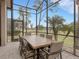 Screened patio with dining table and chairs, offering a view of the golf course at 296 Del Sol Ave, Davenport, FL 33837
