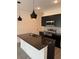 Modern kitchen with dark cabinetry, granite island, and pendant lights at 3237 Energy Drive, Kissimmee, FL 34747