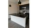 Modern kitchen with dark cabinetry, granite island, and pendant lights at 3237 Energy Drive, Kissimmee, FL 34747