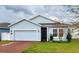 Cute light blue house with a red brick driveway and a two-car garage at 421 Disa Dr, Davenport, FL 33837
