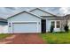 Light blue house with a red brick driveway and a two-car garage at 421 Disa Dr, Davenport, FL 33837