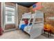 A bedroom with a bunk bed, brick wall, and American flag at 4370 Rhyme St, Kissimmee, FL 34746