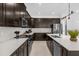 Modern kitchen with dark cabinetry, stainless steel appliances, and white countertops at 4370 Rhyme St, Kissimmee, FL 34746