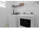 Bright laundry room, washer, dryer, and shelving at 4370 Rhyme St, Kissimmee, FL 34746