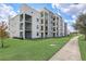 Modern apartment building with landscaped grounds and walking path at 4741 Clock Tower Dr # 306, Kissimmee, FL 34746