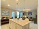 Modern kitchen with white cabinets, island and dining area at 4741 Clock Tower Dr # 306, Kissimmee, FL 34746