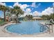 Community pool with lounge chairs and palm trees at 4741 Clock Tower Dr # 306, Kissimmee, FL 34746