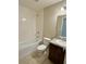 Clean bathroom featuring a shower over bath, tile floors and a granite vanity with updated fixtures at 505 Pentas Ln, Haines City, FL 33844