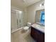 Bright bathroom featuring a glass door shower, tile flooring, and a granite vanity with updated fixtures at 505 Pentas Ln, Haines City, FL 33844