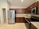 Modern kitchen featuring stainless steel appliances, granite countertops, and ample cabinet space for storage at 505 Pentas Ln, Haines City, FL 33844