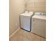 Bright laundry room featuring a washer, dryer and shelving at 505 Pentas Ln, Haines City, FL 33844
