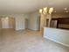 Bright, open-concept living and dining area featuring tile floors, neutral walls, and a modern chandelier at 505 Pentas Ln, Haines City, FL 33844