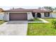 Single-story home with attached garage and landscaped yard at 667 Heraldo Ct, Kissimmee, FL 34758