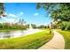 Landscaped walking path alongside a pond with a fountain at 8296 Portofino Dr # 102, Davenport, FL 33896