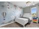 Bedroom with a world map accent wall, full-size bed, and nightstand at 8985 Stinger Dr, Davenport, FL 33896