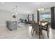 Open dining area with modern light fixture and seating for six at 8985 Stinger Dr, Davenport, FL 33896
