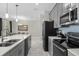 Modern gray kitchen with stainless steel appliances and breakfast bar at 8985 Stinger Dr, Davenport, FL 33896