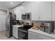 White kitchen features stainless steel appliances and quartz countertops at 1254 Wispy Cypress Dr, Kissimmee, FL 34746