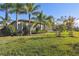 Landscaped backyard with palm trees and home at 135 Lemon Grove Dr, Poinciana, FL 34759