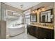 Elegant bathroom with double vanity, soaking tub, and mosaic tile at 135 Lemon Grove Dr, Poinciana, FL 34759