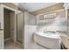 Bathroom with a soaking tub, glass shower, and mosaic tile at 135 Lemon Grove Dr, Poinciana, FL 34759