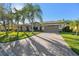 Single-story home with paver driveway, landscaping, and palm trees at 135 Lemon Grove Dr, Poinciana, FL 34759