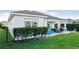 Landscaped backyard with patio, grass, and privacy hedge at 2937 Bella Flore Ter, New Smyrna Beach, FL 32168