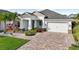 Single story home with white exterior, landscaping, and paver driveway at 2937 Bella Flore Ter, New Smyrna Beach, FL 32168