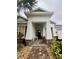 Brick walkway leads to a charming front porch with rocking chairs at 2937 Bella Flore Ter, New Smyrna Beach, FL 32168