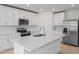 Modern kitchen featuring white cabinets, stainless steel appliances, and a large island at 3142 Viceroy Ct, Poinciana, FL 34759
