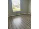 Bedroom with wood-look floors and a window with blinds at 3209 Windover Ave, Kissimmee, FL 34741