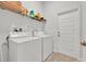 Practical laundry room featuring a washer, dryer, and storage shelves at 434 Panaro Ln, Haines City, FL 33844