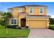 Two-story house with a two-car garage and landscaped lawn at 4439 Shiva Loop, Kissimmee, FL 34746