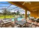 Screened-in pool and spa with patio furniture and lake views at 4439 Shiva Loop, Kissimmee, FL 34746