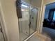 Bathroom shower with glass door, light tile, and a view into the Primary bedroom at 446 Citrus Isle Loop, Davenport, FL 33837