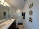 Bright bathroom with double vanity, granite countertop, decorative mirrors, and a bathtub-shower combo at 446 Citrus Isle Loop, Davenport, FL 33837