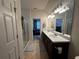 Bathroom with double vanity sinks, brown cabinetry, and view into the shower and bedroom at 446 Citrus Isle Loop, Davenport, FL 33837