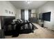 Modern bedroom with a dark, upholstered bed frame, dark dresser, and mounted television at 446 Citrus Isle Loop, Davenport, FL 33837