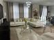 Bright living room featuring a modern white sectional, stylish glass coffee table, and contemporary lighting fixture at 446 Citrus Isle Loop, Davenport, FL 33837