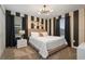 Bedroom with a king-size bed, black and white striped walls, and modern decor at 4575 Narrative Ln, Kissimmee, FL 34746