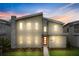 Modern two-story home with red front door, illuminated at night at 4575 Narrative Ln, Kissimmee, FL 34746