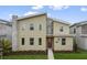 Two-story house with a modern design, red door, and landscaping at 4575 Narrative Ln, Kissimmee, FL 34746