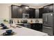 Modern kitchen with dark cabinets, quartz countertops, and stainless steel appliances at 4575 Narrative Ln, Kissimmee, FL 34746