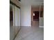 Hallway with tile flooring and a large mirrored closet, leading to other rooms at 4824 Shoshone St, Orlando, FL 32819