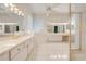 Large bathroom with double vanity and walk-in shower at 5666 Merlin Way, St Cloud, FL 34772