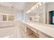 Large bathroom with double vanity and walk-in shower at 5666 Merlin Way, St Cloud, FL 34772